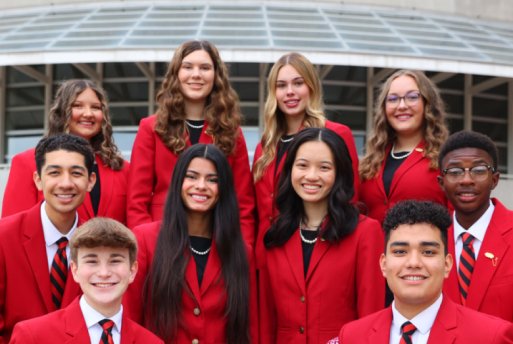 a diverse group of high school students in matching red blazers